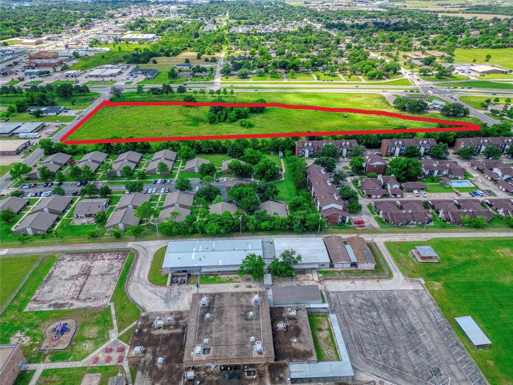 0000 King Street, Greenville, TX 75401 Expansive vacant land parcel featuring significant street frontage, level topography, and established clusters of mature trees
