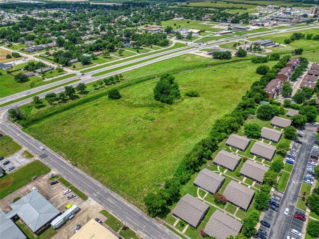 0000 King Street, Greenville, TX 75401 Expansive acreage featuring prominent street frontage, significant open green space, mature tree clusters, and direct access to established thoroughfares