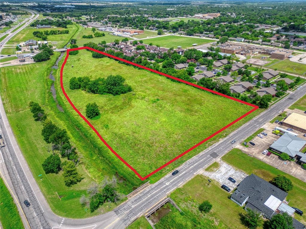 0000 King Street, Greenville, TX 75401 Expansive parcel of land featuring open green space, mature trees, and frontage along a paved thoroughfare