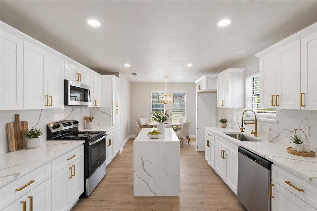 5514 Round Rock Road, Garland, TX 75044 Kitchen featuring white cabinetry with brass-finish hardware, stone-patterned countertops, a central island, recessed lighting, and wood-finish flooring