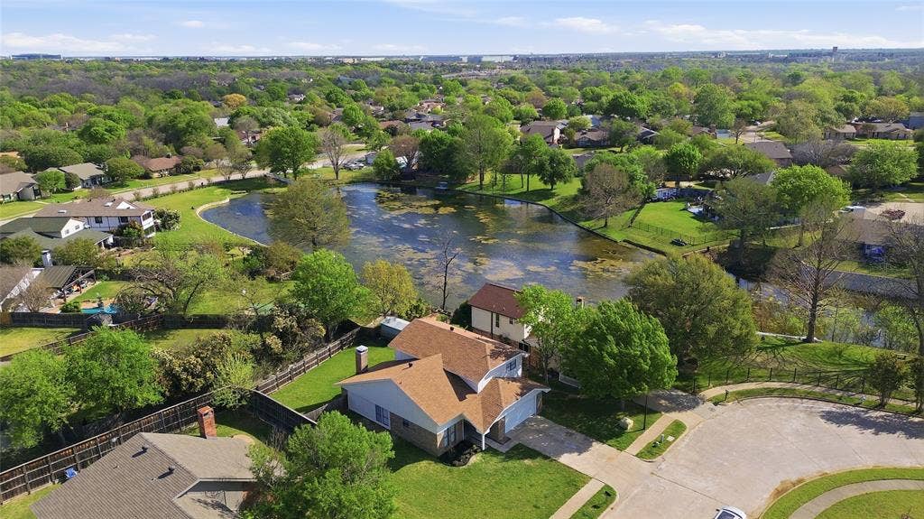 5514 Round Rock Road, Garland, TX 75044 Aerial perspective featuring a multi-story residence with a shingled roof, attached garage, and a fenced backyard