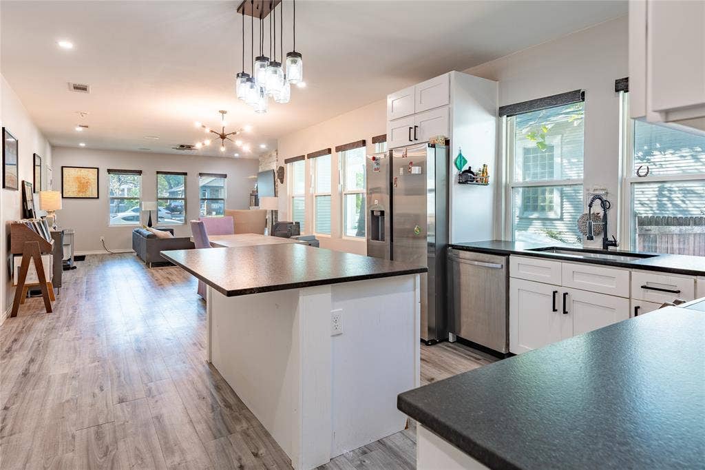 608 N Edgefield Avenue, Dallas, TX 75208 The open floor plan creates a window-lined great room with a kitchen, dining room, and living room.