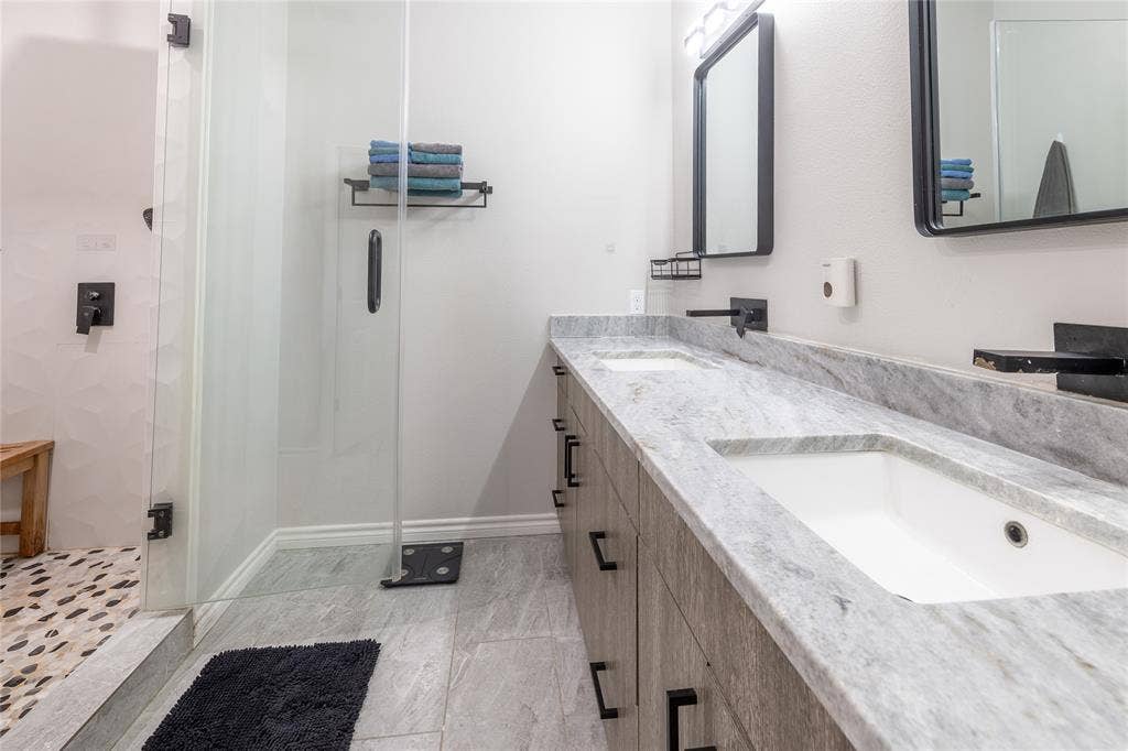 608 N Edgefield Avenue, Dallas, TX 75208 Updated primary bathroom with a walk-in shower, stone countertops, dual undermounted sinks, modern vanity, and modern fixtures.