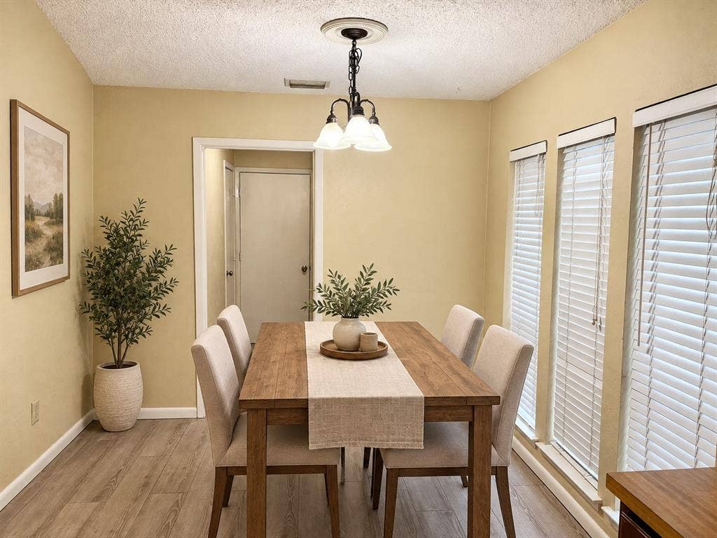 618 Pyramid Drive, Garland, TX 75040 Wood-finish flooring, multi-pane light fixture with a ceiling medallion, and a series of three windows featuring horizontal blinds