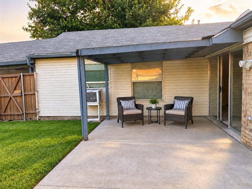 618 Pyramid Drive, Garland, TX 75040 Covered concrete patio featuring a structural pergola, light-colored horizontal siding, and wood-panel fencing