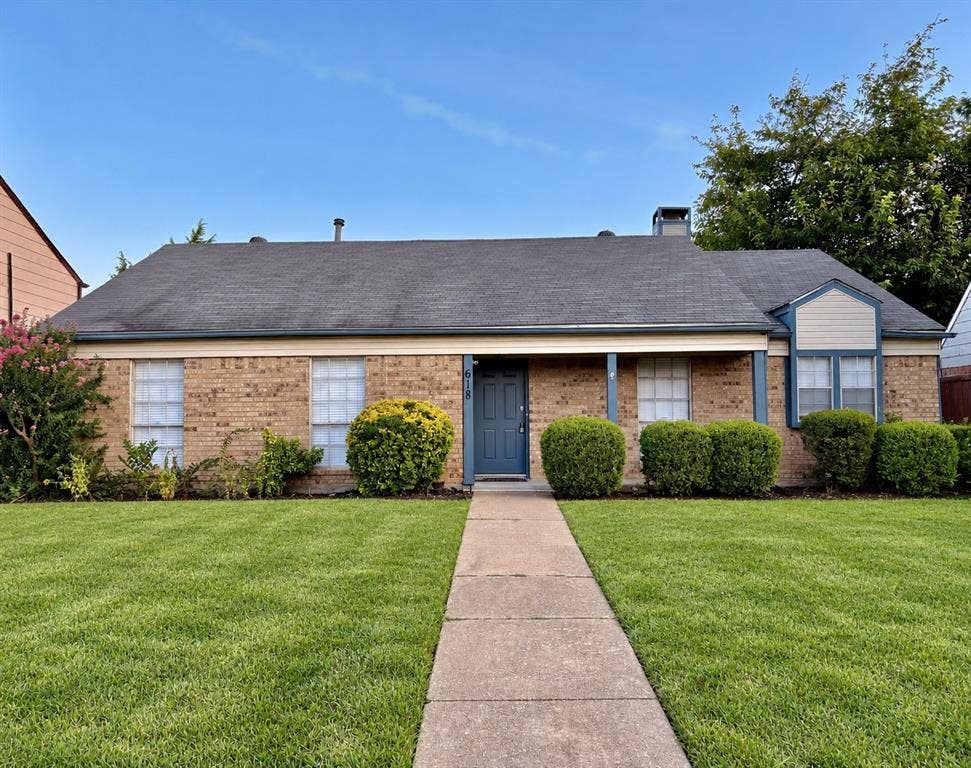 618 Pyramid Drive, Garland, TX 75040 Single-story brick exterior featuring a covered front porch, multi-pane windows, a bay window element, and a concrete walkway