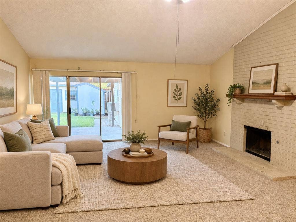618 Pyramid Drive, Garland, TX 75040 Vaulted ceiling, floor-to-ceiling brick fireplace with a wood mantel, and glass sliding door opening to a concrete patio