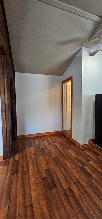 Vaulted ceilings, wood-finish flooring, and natural wood door casing