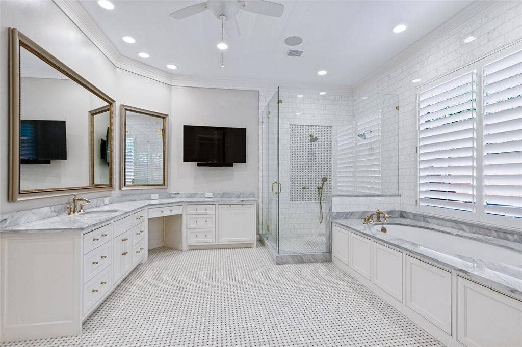 6467 Orchid Lane, Dallas, TX 75230 Luxurious Primary Bath provides beautiful marble countertops, soaking tub, and frameless glass shower. View of "her" vanity.