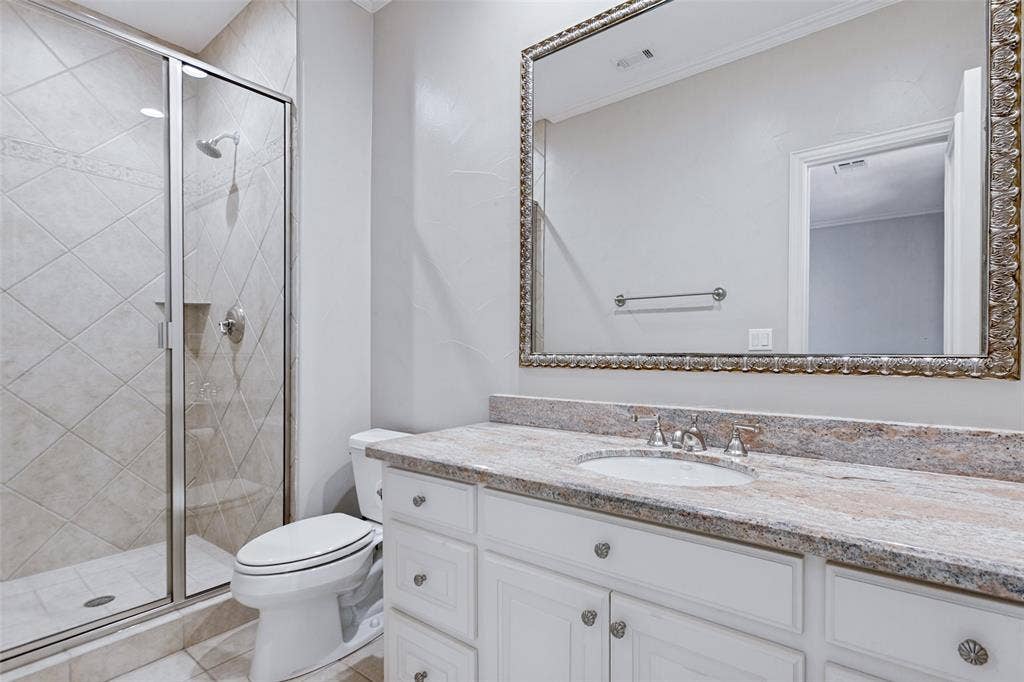 6467 Orchid Lane, Dallas, TX 75230 An example of a private bath with one of the bedrooms. Stunning marble and framed mirror.