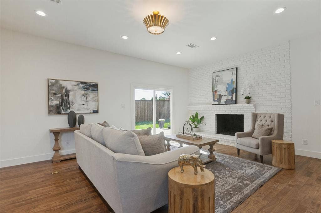 304 S Weatherred Drive, Richardson, TX 75080 Living area featuring wood-finish flooring, white-painted brick fireplace, recessed lighting, decorative flush-mount fixture, and sliding glass doors