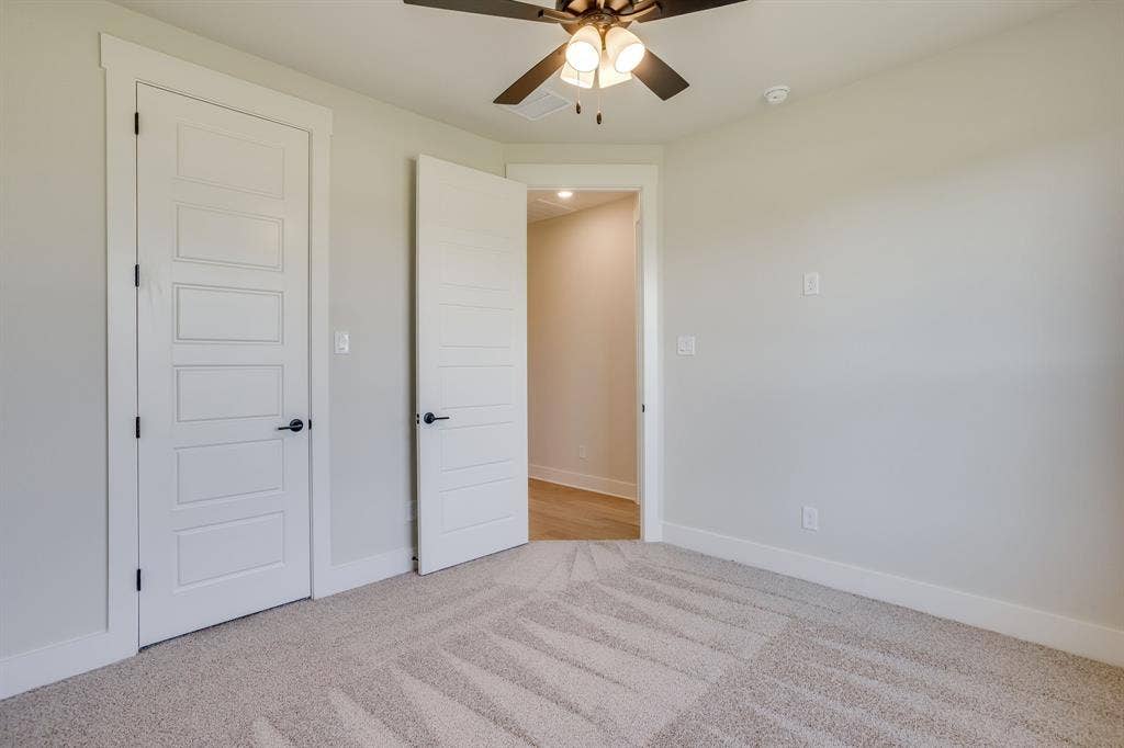 501 Olson Road, Waxahachie, TX 75167 Neutral-toned carpeted flooring, five-panel shaker-style interior doors with matte black hardware, and an overhead ceiling fan with integrated lighting
