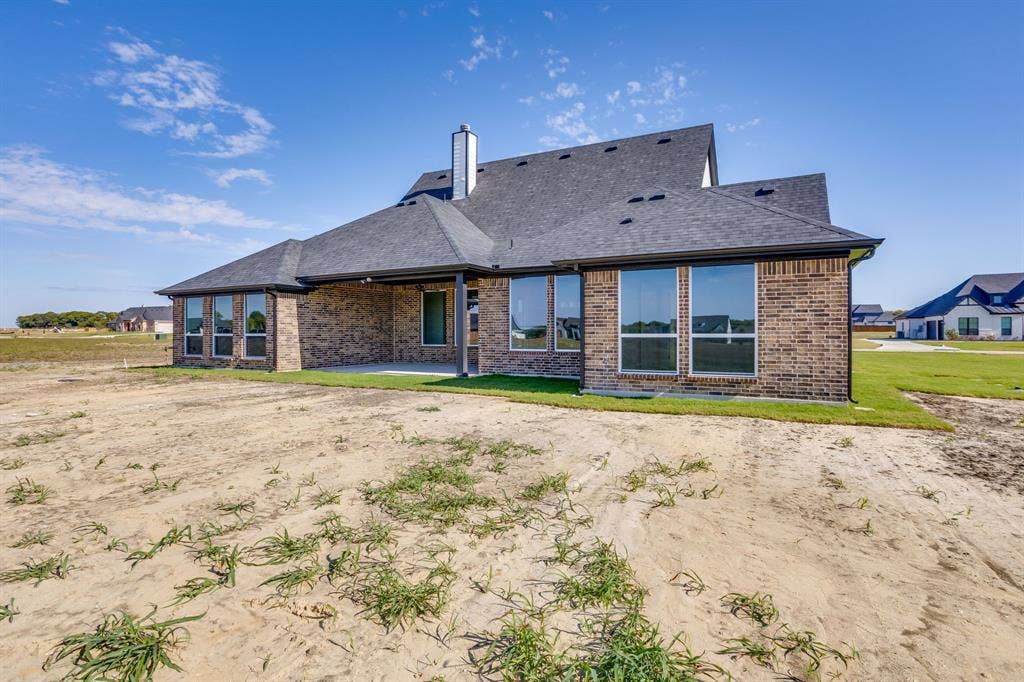 501 Olson Road, Waxahachie, TX 75167 Brick exterior featuring a covered patio, pitched roofline, chimney stack, and multi-pane windows
