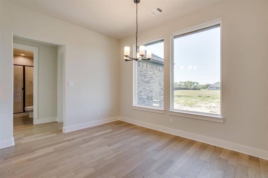 501 Olson Road, Waxahachie, TX 75167 Wood-finish flooring, tall windows, and a multi-light chandelier