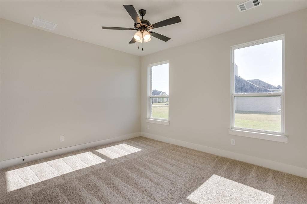 501 Olson Road, Waxahachie, TX 75167 Neutral wall palette with carpeted flooring, dual windows, and a ceiling-mounted light fixture with a fan