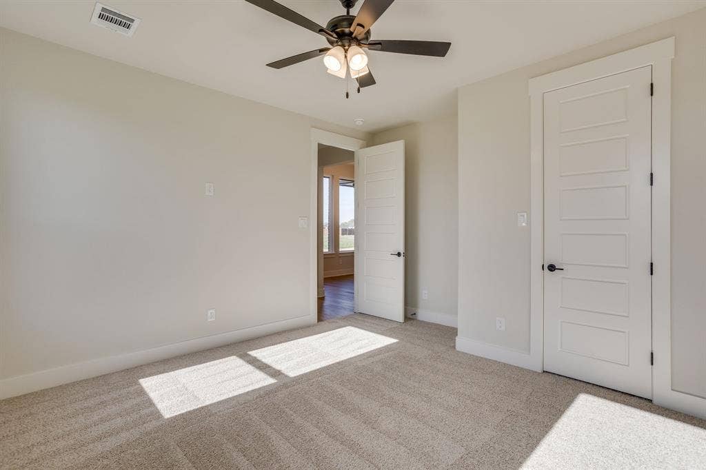 501 Olson Road, Waxahachie, TX 75167 Neutral-toned carpeted flooring, five-panel interior doors, and a ceiling fan with integrated light fixture