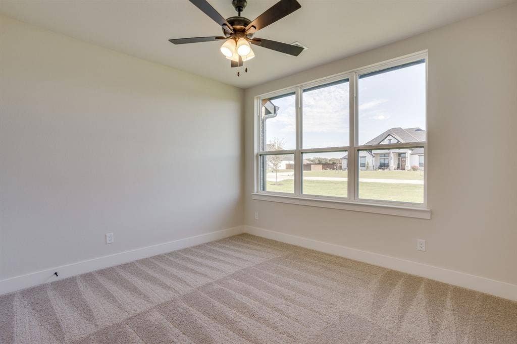 501 Olson Road, Waxahachie, TX 75167 Neutral wall finishes, plush carpeting, multi-pane windows, and a ceiling fan with integrated light fixture