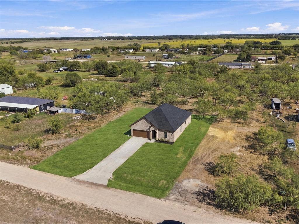 5365 Rabbit Trail, Kemp, TX 75143 Single-story residence featuring a brick exterior, dark asphalt shingle roof, attached garage, and a concrete driveway situated on a expansive lot
