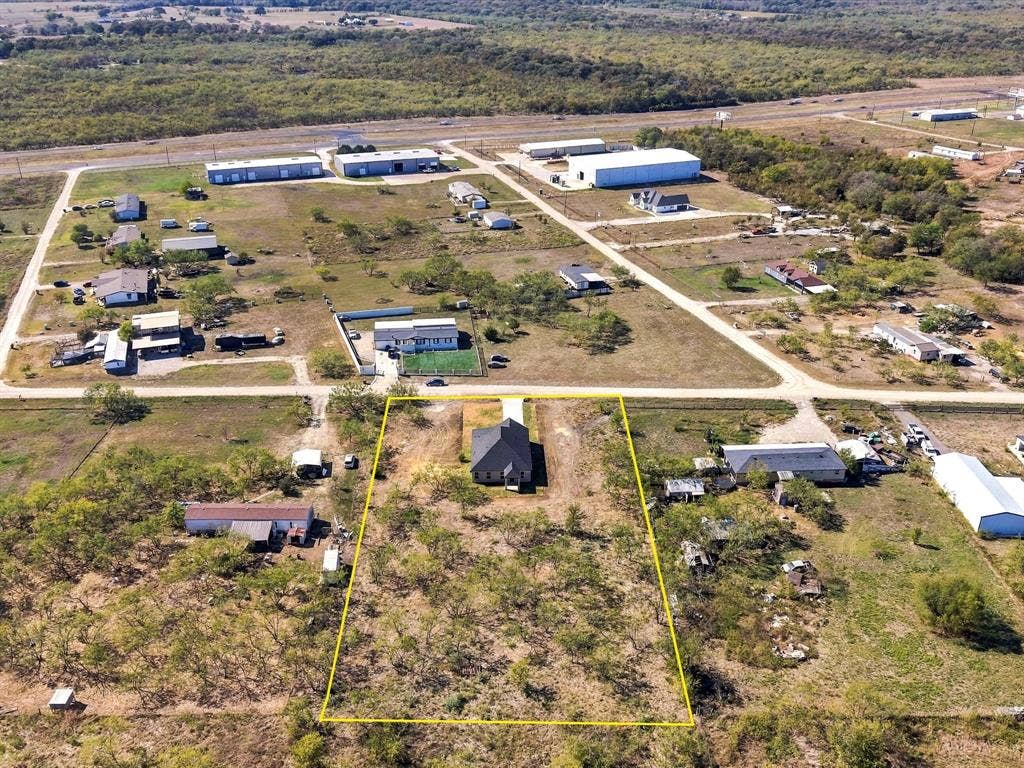 5365 Rabbit Trail, Kemp, TX 75143 Aerial perspective of an expansive residential lot featuring mature trees, a concrete driveway, and a detached single-story residence with a dark-toned pitched roof