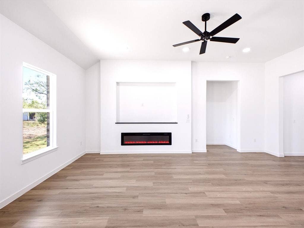 5365 Rabbit Trail, Kemp, TX 75143 Wood-finish flooring, recessed lighting, matte black ceiling fan, and built-in wall niche with integrated electric fireplace