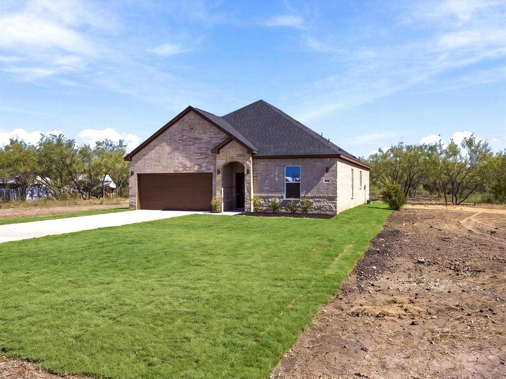 5365 Rabbit Trail, Kemp, TX 75143 Single-story residence featuring a brick and stone exterior, hipped roof, attached two-car garage, and a concrete driveway