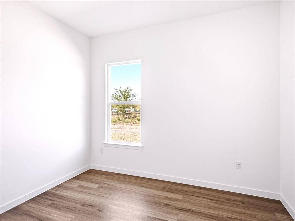5365 Rabbit Trail, Kemp, TX 75143 Neutral-toned walls, wood-finish flooring, and a vertical window providing natural illumination