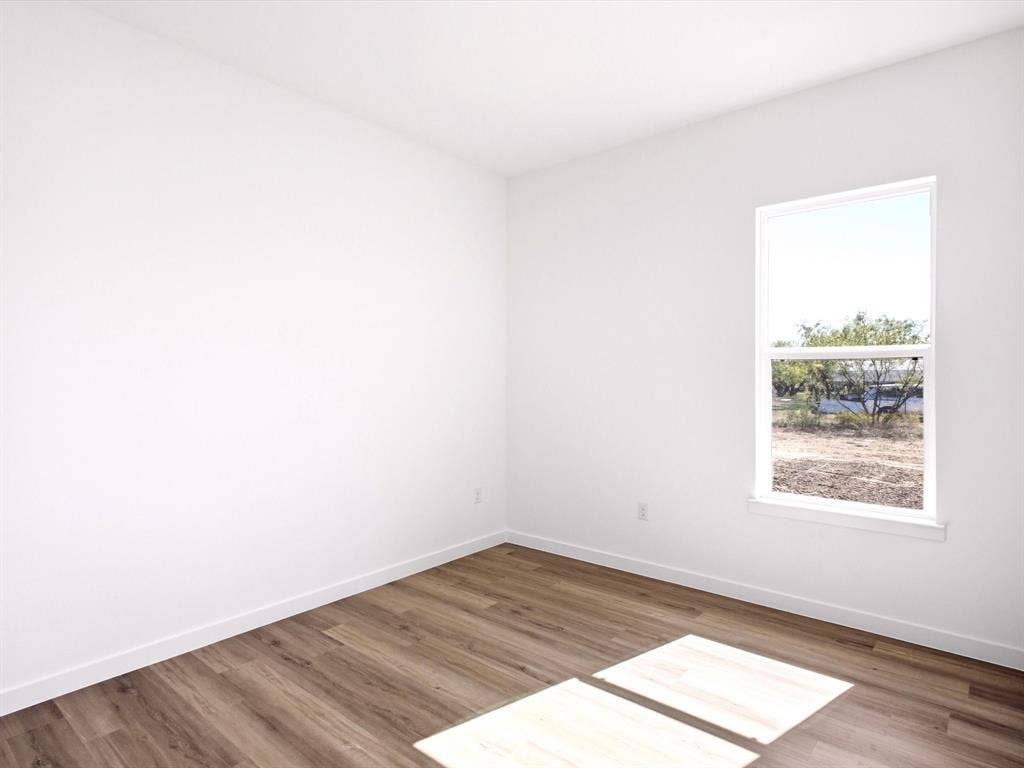 5365 Rabbit Trail, Kemp, TX 75143 Neutral interior featuring white walls and wood-finish flooring with a single-pane window