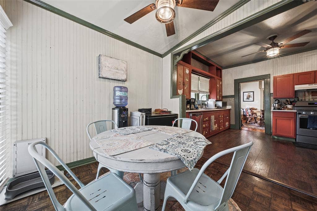 406 Summit Street, Farmersville, TX 75442 Kitchen area featuring beadboard wall paneling, hardwood flooring, ceiling-mounted paddle fans, and built-in cabinetry