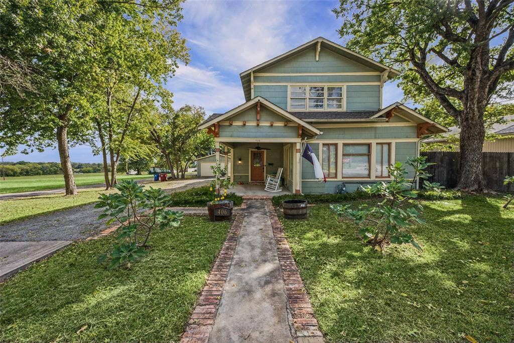 406 Summit Street, Farmersville, TX 75442 Two-story Craftsman-style exterior featuring horizontal siding, a covered front porch with decorative brackets, and a brick-bordered concrete walkway