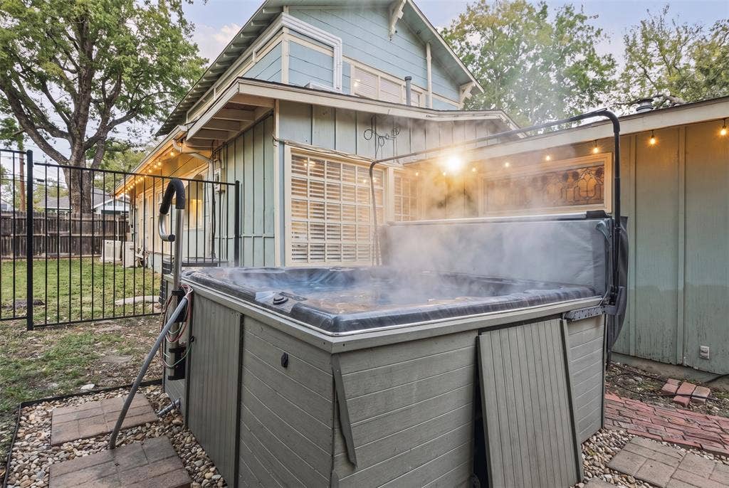 406 Summit Street, Farmersville, TX 75442 Outdoor space featuring an elevated hot tub with an integrated cover lift system, set on a stone-paver foundation within a fenced perimeter