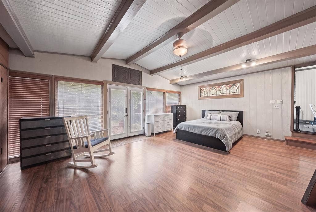 406 Summit Street, Farmersville, TX 75442 Vaulted ceilings with exposed wooden beams, wood-finish flooring, dual glass-panel exterior doors, and an elongated decorative leaded-glass window