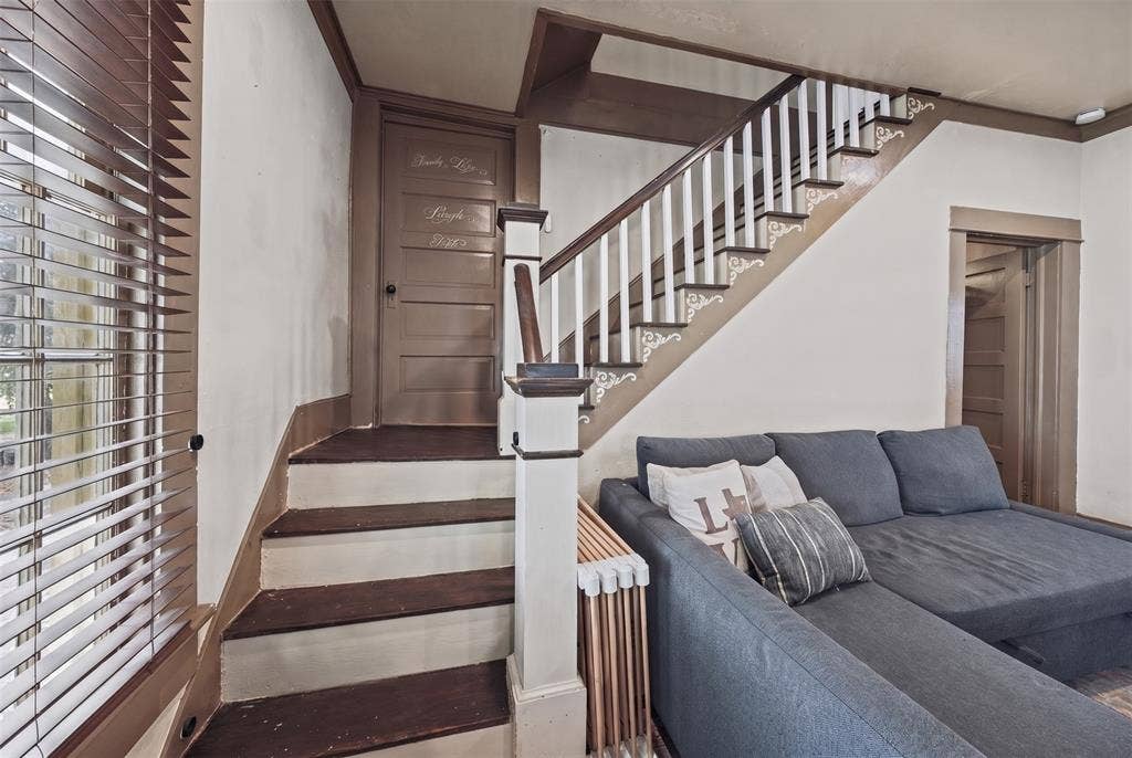 406 Summit Street, Farmersville, TX 75442 Staircase featuring dark wood-finish treads, decorative millwork accents, and a classic wood-and-white balustrade