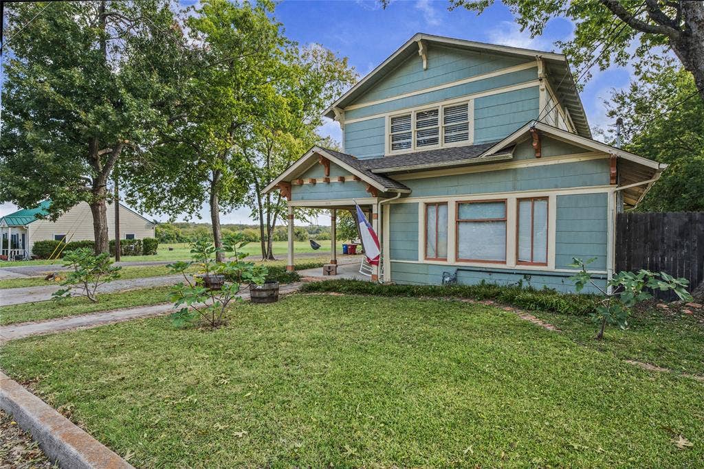 406 Summit Street, Farmersville, TX 75442 Two-story Craftsman-style exterior featuring horizontal siding, decorative gable brackets, a covered front porch, and multi-pane windows