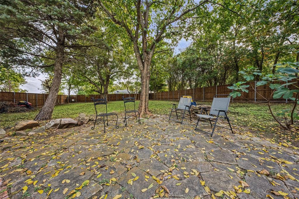 406 Summit Street, Farmersville, TX 75442 Flagstone patio featuring mature trees, natural rock outcroppings, and perimeter wood fencing