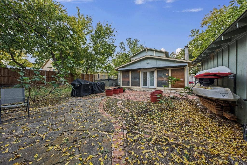 406 Summit Street, Farmersville, TX 75442 Backyard featuring a flagstone patio with brick border, a separate paved brick area, and tall privacy fencing