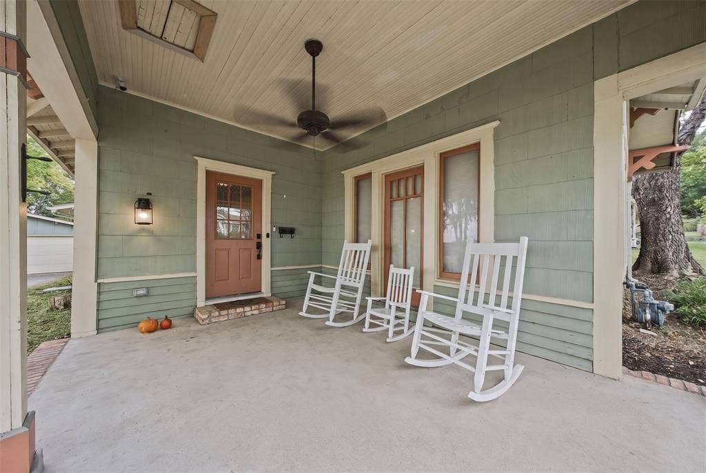 406 Summit Street, Farmersville, TX 75442 Covered front porch featuring wood-shingle siding, beadboard ceiling, brick-trimmed entryway, and a ceiling fan