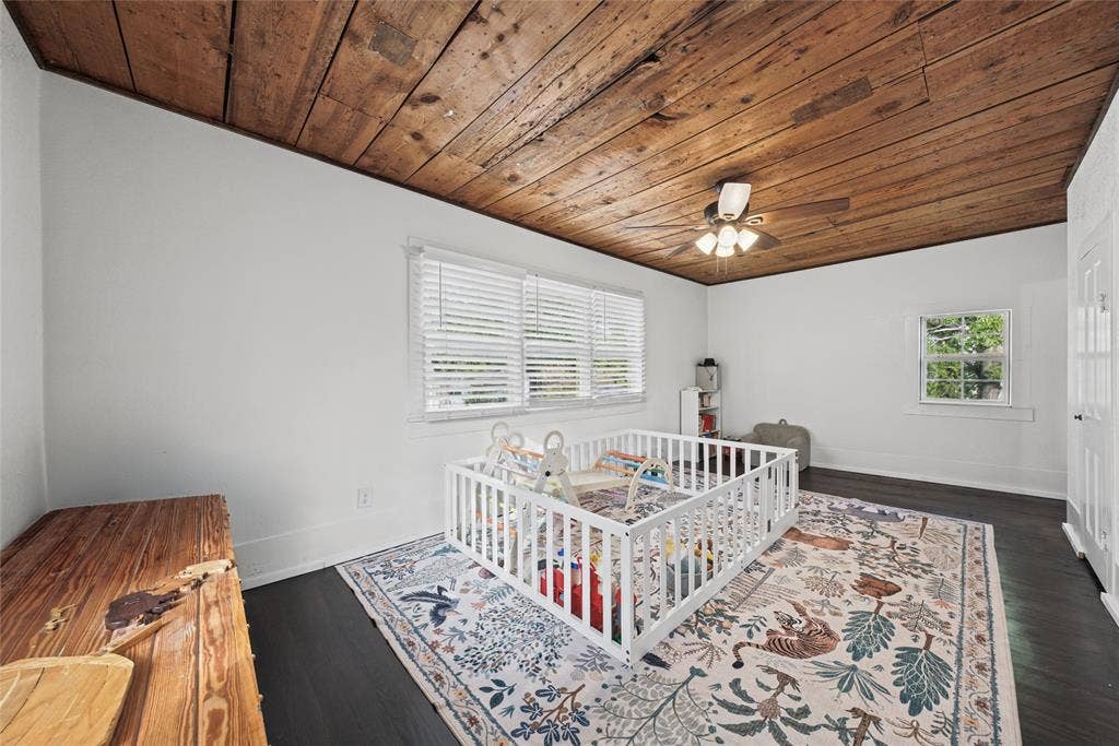 406 Summit Street, Farmersville, TX 75442 Room featuring a natural wood-plank ceiling, dark wood-finish flooring, multi-pane windows with horizontal blinds, and a central ceiling fan with integrated lighting