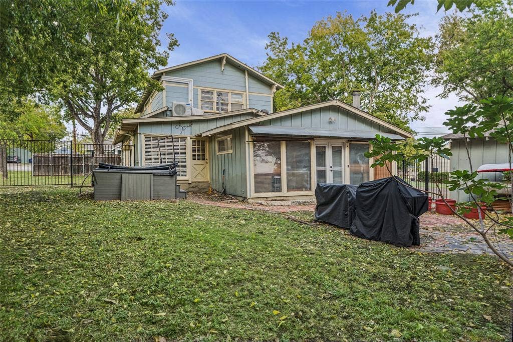 406 Summit Street, Farmersville, TX 75442 Two-story residence featuring vertical siding, a paved patio area, metal perimeter fencing, and mature trees