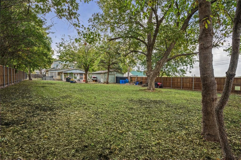 406 Summit Street, Farmersville, TX 75442 Expansive backyard featuring a fenced perimeter, mature trees, and a detached structure