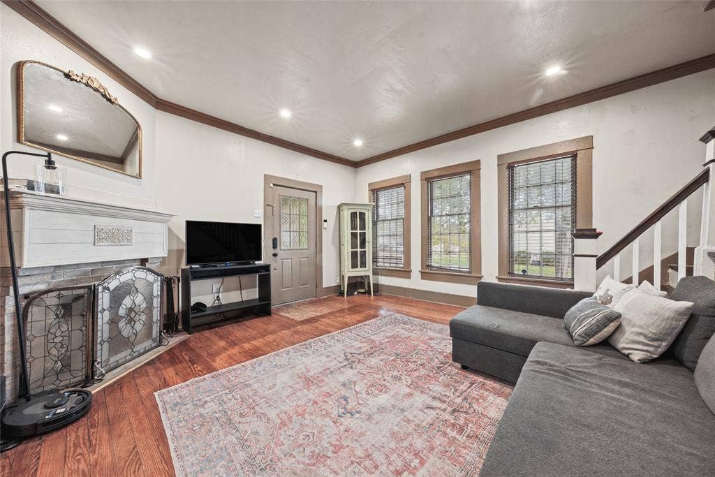 406 Summit Street, Farmersville, TX 75442 Living area featuring wood-finish flooring, recessed lighting, crown molding, and a fireplace with a decorative mantel and hearth screen