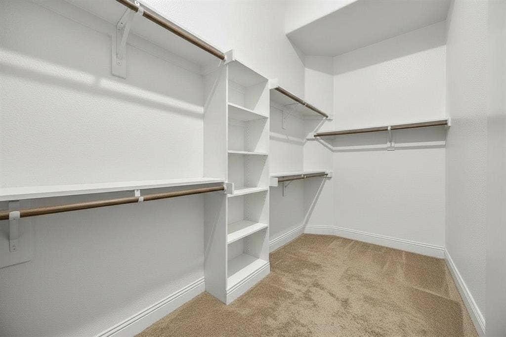 3702 Harlan Drive, Sachse, TX 75048 Spacious primary walk-in closet offers built-in shelving and multiple hanging areas for organized storage.