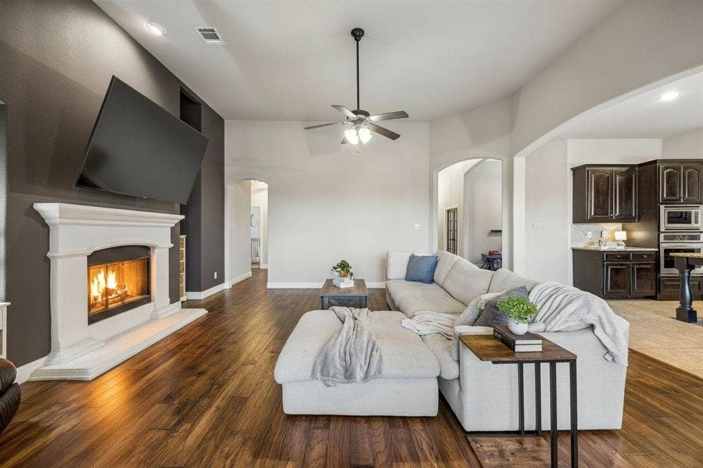 3702 Harlan Drive, Sachse, TX 75048 Spacious family room features updated lighting, warm wood flooring, fireplace and an open connection to the kitchen and breakfast area.