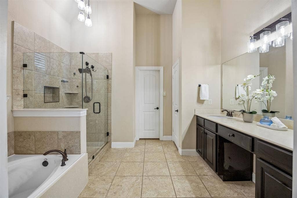 3702 Harlan Drive, Sachse, TX 75048 Primary bath features dual vanities, soaking tub and an upgraded frameless glass shower enclosure.