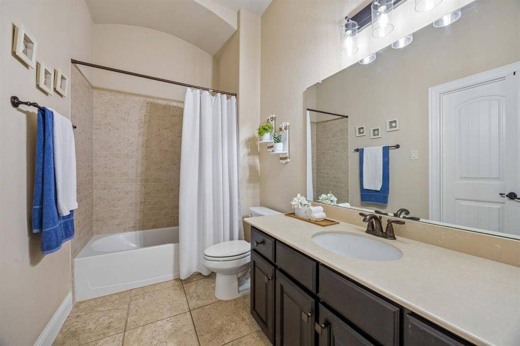 3702 Harlan Drive, Sachse, TX 75048 Full secondary bathroom serves the first-floor bedrooms and features a dual-sink vanity.