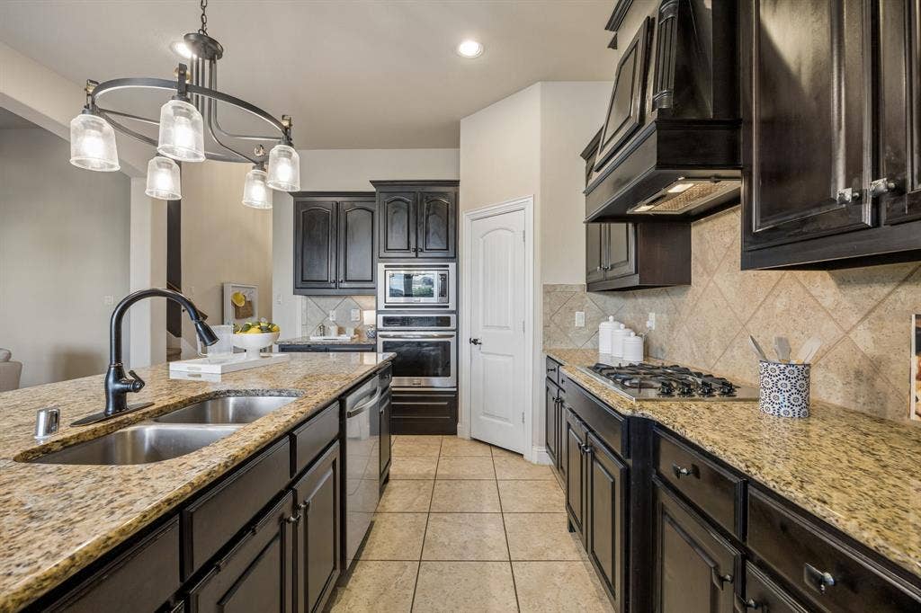 3702 Harlan Drive, Sachse, TX 75048 Granite countertops, stainless steel appliances, espresso cabinetry and updated lighting complete the kitchen.