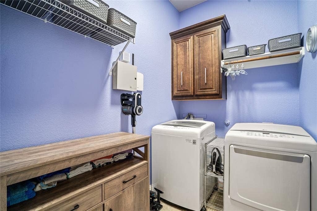 Laundry space featuring built-in dark wood-finish wall cabinetry, a wire shelving system, and a wood-finish storage console