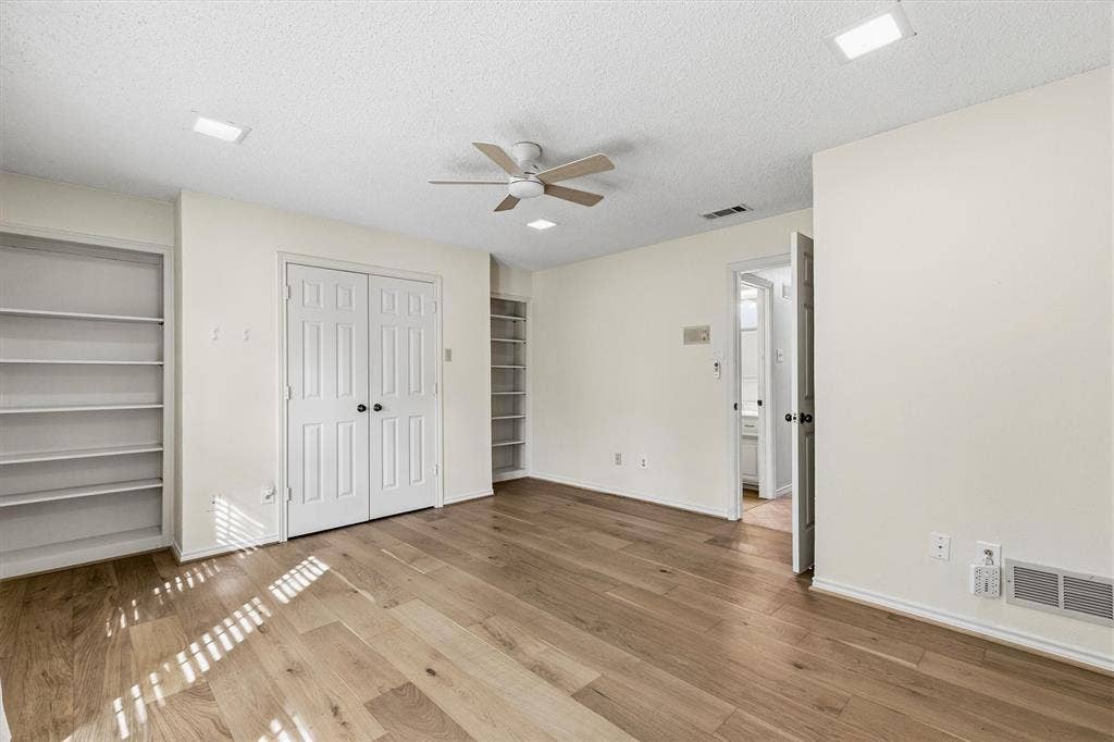 Wood-finish flooring, recessed LED lighting, ceiling fan, double-door closet, and built-in shelving