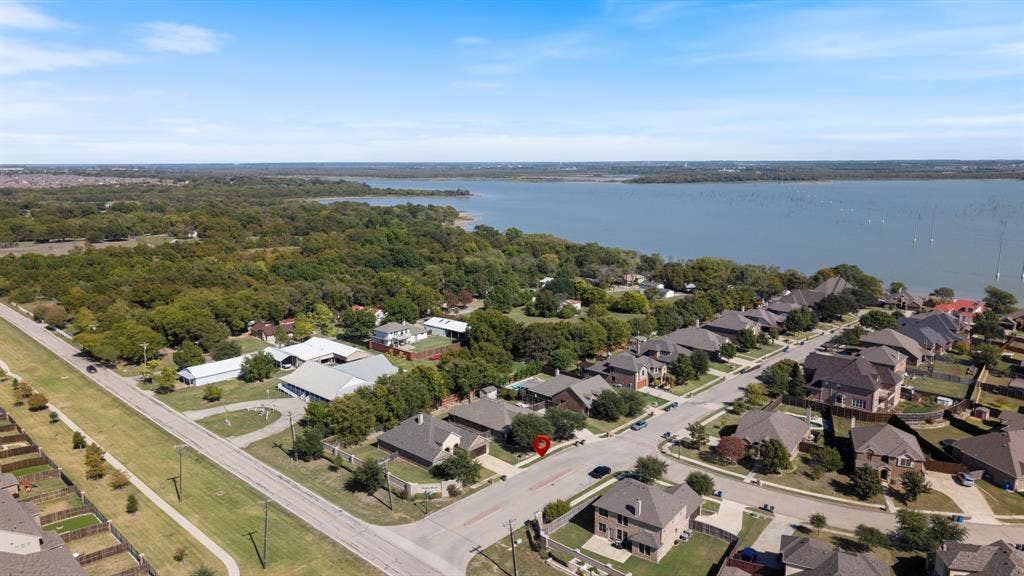 1802 Watermark Lane, Wylie, TX 75098 Aerial perspective showcasing residential positioning near a large lake, mature tree-lined surroundings, and established street infrastructure