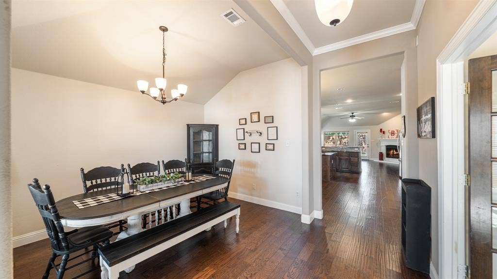 1802 Watermark Lane, Wylie, TX 75098 Vaulted ceilings with crown molding, wood-finish flooring, and a multi-light chandelier