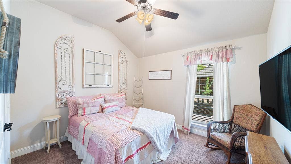 1802 Watermark Lane, Wylie, TX 75098 Vaulted ceiling featuring a central multi-blade ceiling fan with integrated light fixture and carpeted flooring